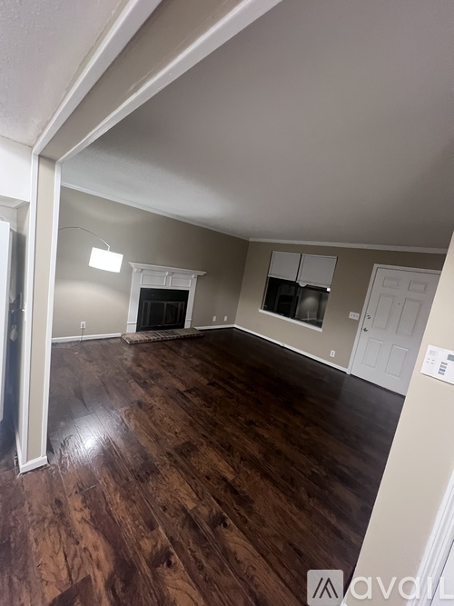 A room with wood flooring and white walls.