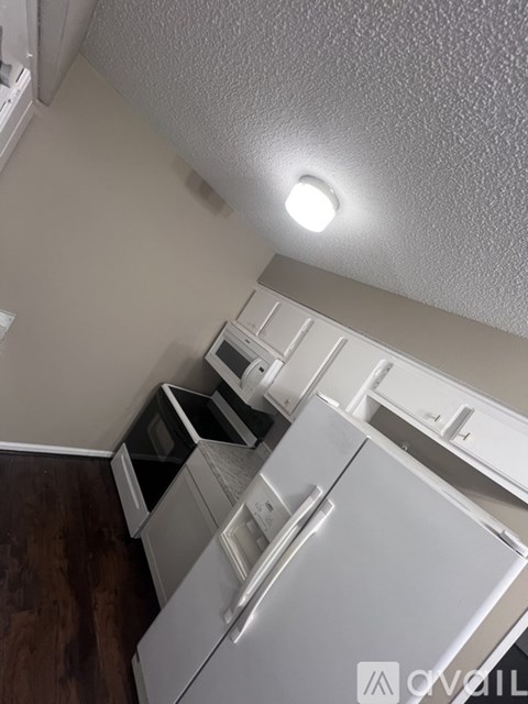 A white fridge in a kitchen with a microwave and oven built in.