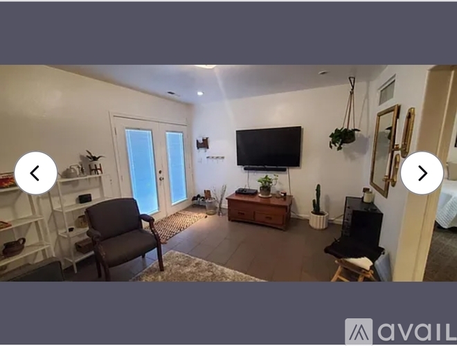 A living room with a television, a chair, and a table.