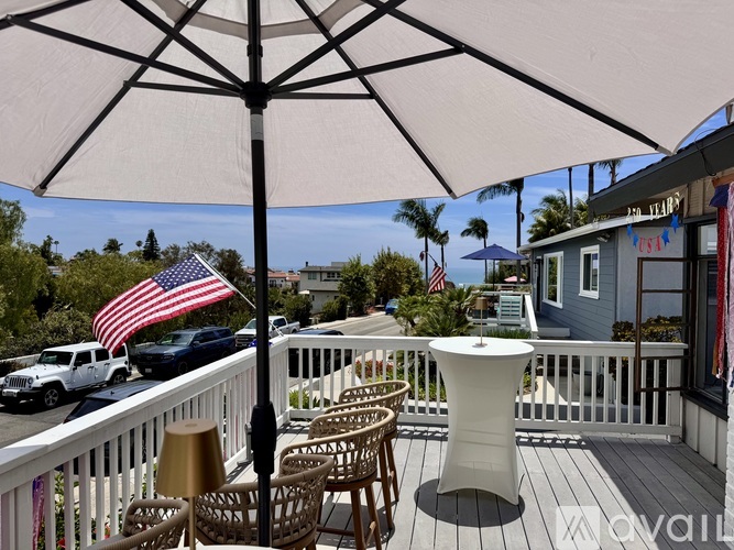 A patio with a table and chairs under an umbrella with an American flag.