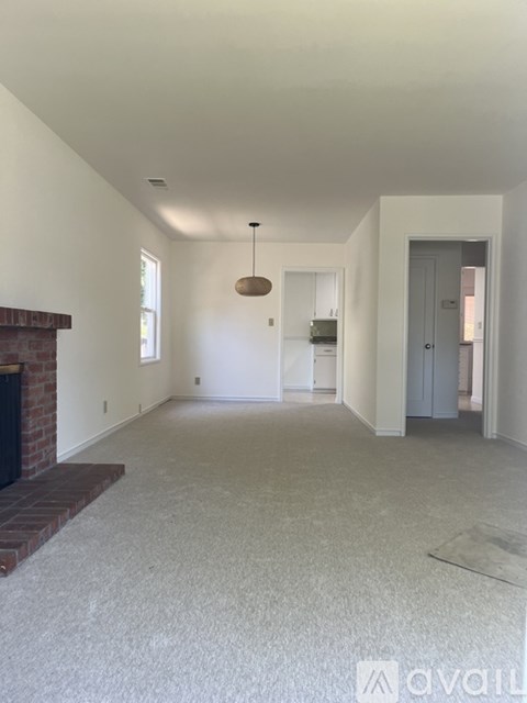A living room with a fireplace and a rug on the floor.