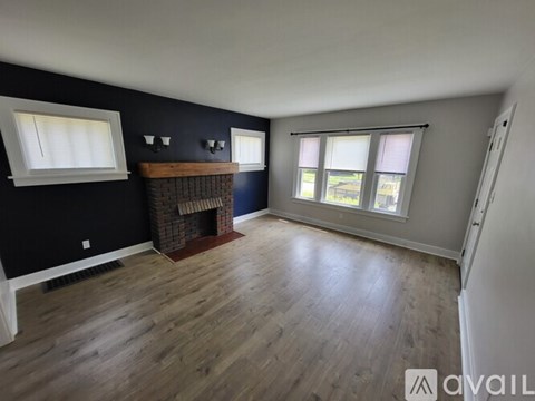 A room with a fireplace and wooden flooring.