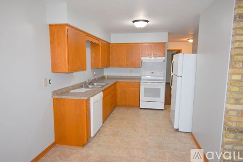A kitchen with wooden cabinets and a white fridge.