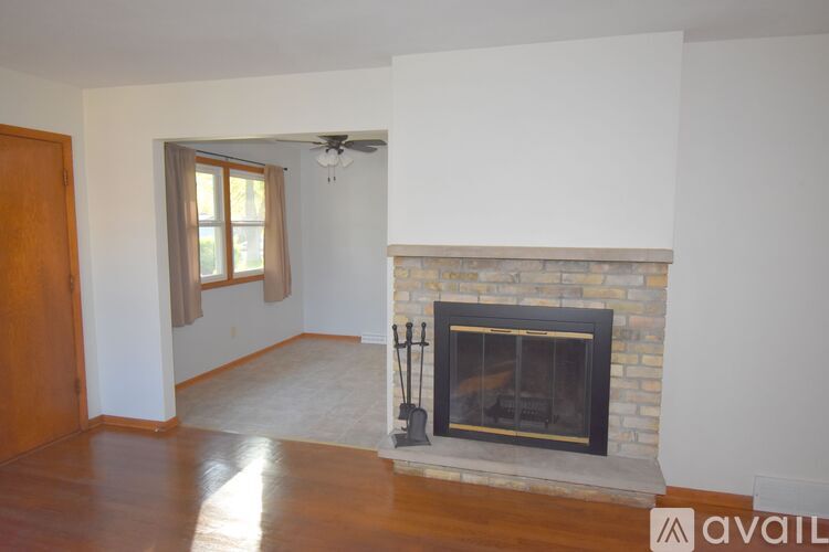 A living room with a fireplace and a fan.