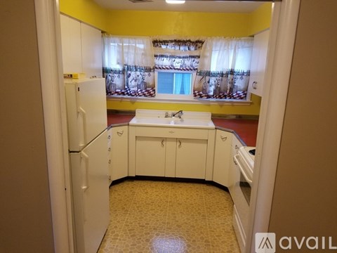A kitchen with yellow walls and white appliances.