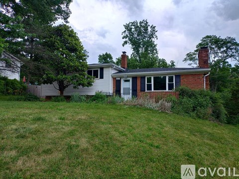 A house with a blue door is surrounded by greenery.