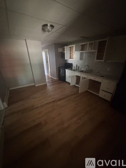 A kitchen with wooden floors and white cabinets.