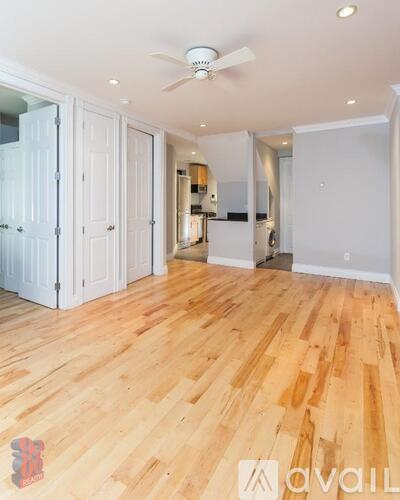 A room with wooden flooring and a ceiling fan.