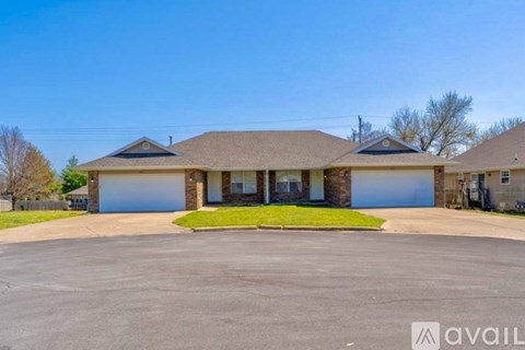 A house with a large front yard and two garages.
