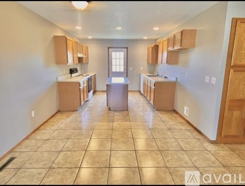 A kitchen with wooden cabinets and a tiled floor.