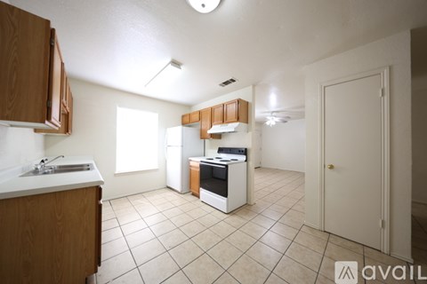 A kitchen with white appliances and wooden cabinets.