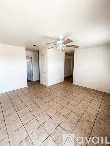 A spacious room with a ceiling fan and tiled flooring.