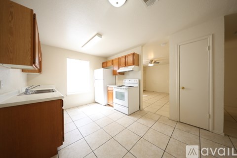 A kitchen with white appliances and brown cabinets.