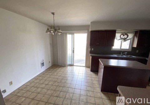 A kitchen with brown cabinets and a tiled floor.
