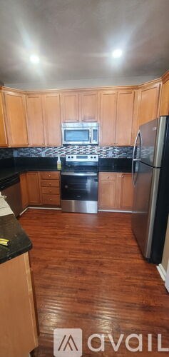 A kitchen with wooden cabinets and a black countertop.