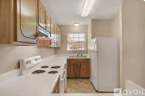 A kitchen with a white stove top and a white refrigerator.