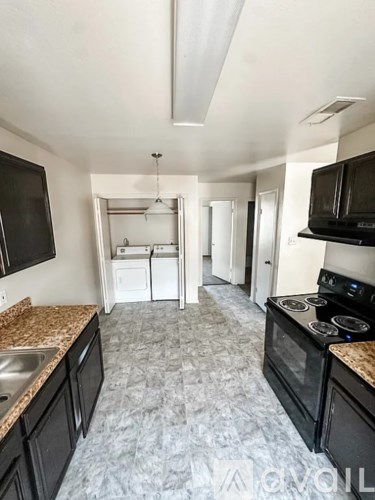 A kitchen with black cabinets and a granite counter top.