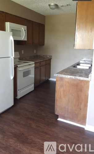 A kitchen with a white refrigerator and wooden cabinets.