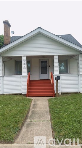 A white house with a red staircase leading to the front door.