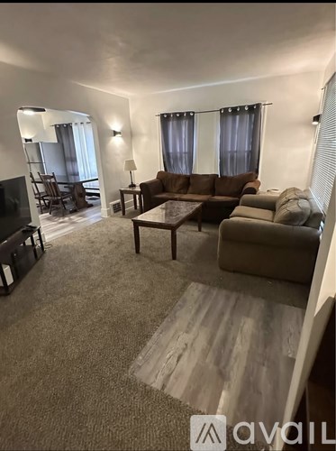 A living room with a brown couch and a television.