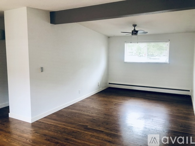 A room with wooden floors and a ceiling fan.