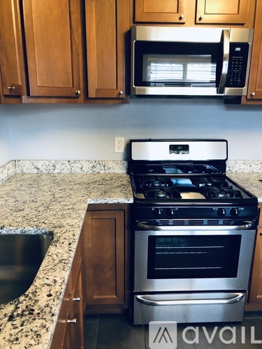 A kitchen with a granite countertop and a stainless steel stove.