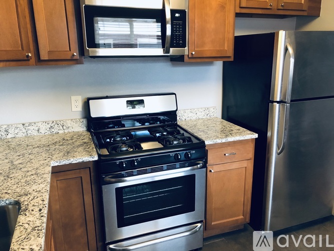 A kitchen with a stove, microwave, and refrigerator.