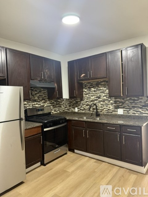 A kitchen with dark wood cabinets and a white fridge.