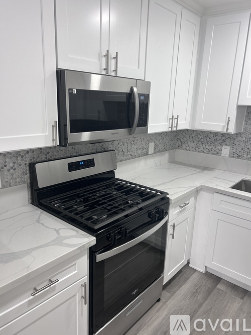 A kitchen with white cabinets and a black stove top oven.