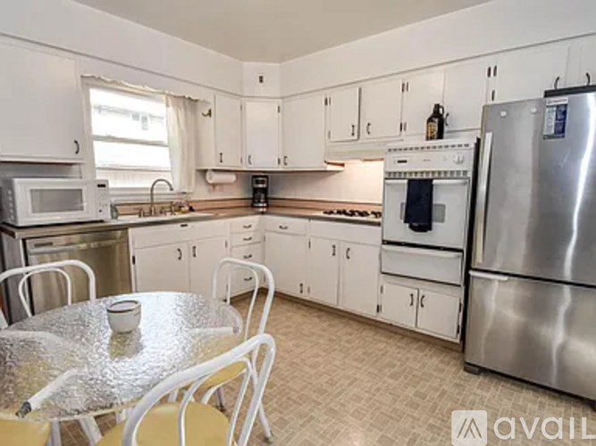 A kitchen with white cabinets and a stainless steel refrigerator.