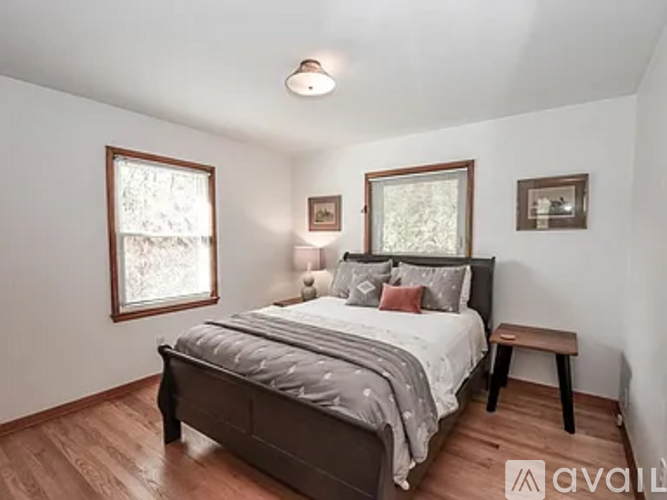 A bedroom with a large bed and a bench.