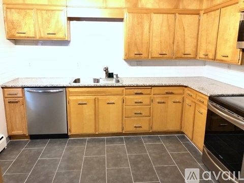 A kitchen with wooden cabinets and a grey countertop.