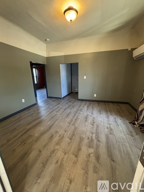 A room with wooden flooring and a ceiling light.