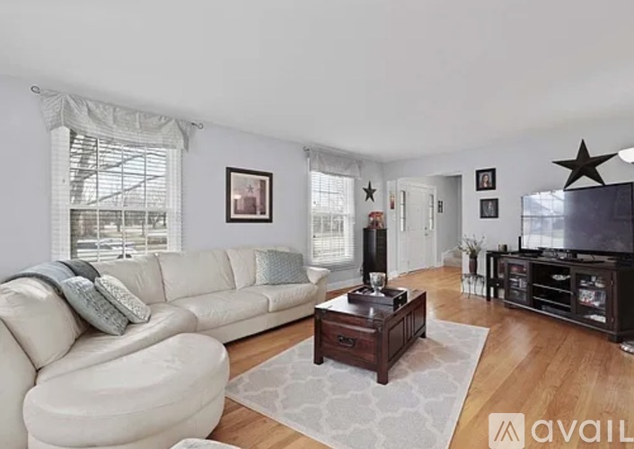 A living room with a white couch and a wooden coffee table.
