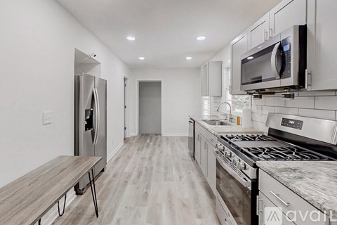 A kitchen with a refrigerator, oven, and microwave.