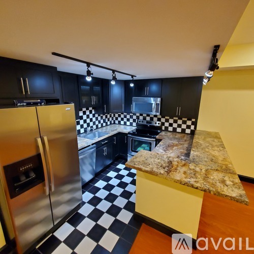 A kitchen with black cabinets and a checkered floor.