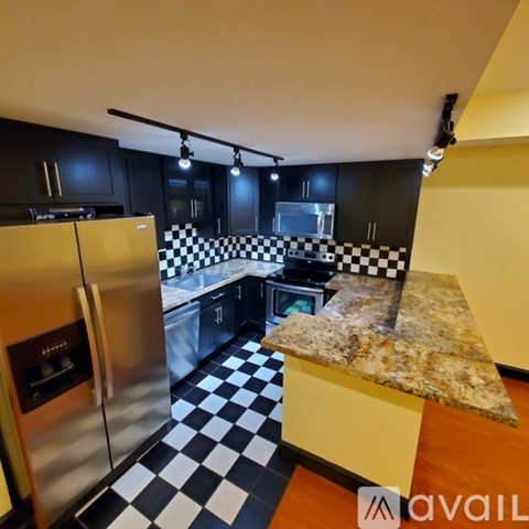A kitchen with black cabinets and a checkered floor.