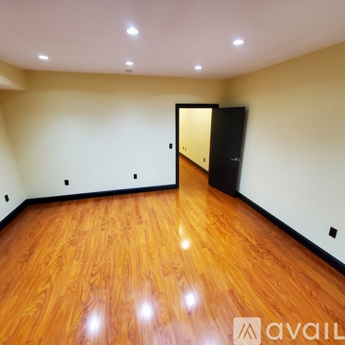A room with wooden flooring and a black door.