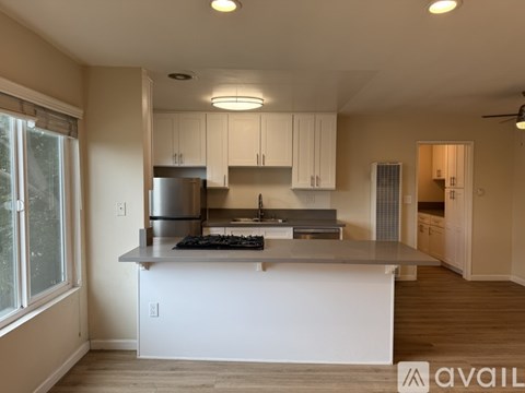 A modern kitchen with white cabinets and a large island.