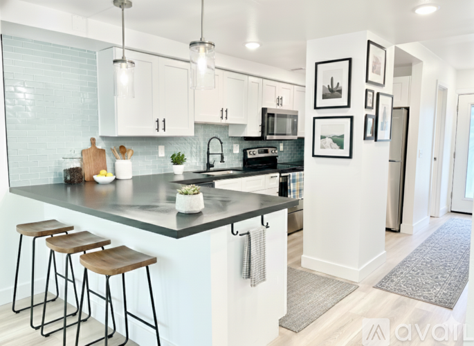 A kitchen with white cabinets and a black countertop.