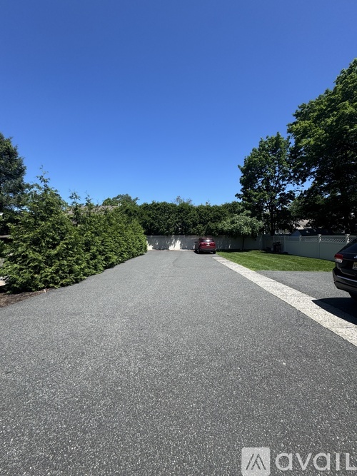 A car is parked on the side of a road with trees on both sides.