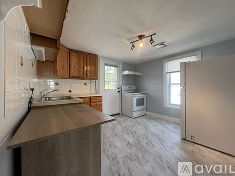 A kitchen with wooden cabinets and a marble floor.