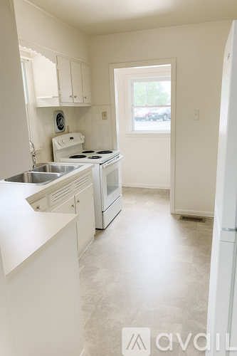 A white kitchen with a sink and stove.