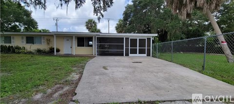 A small building with a white door and a fence in front of it.