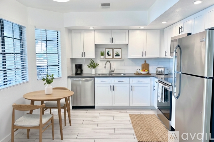 A kitchen with a table and chairs and a refrigerator.