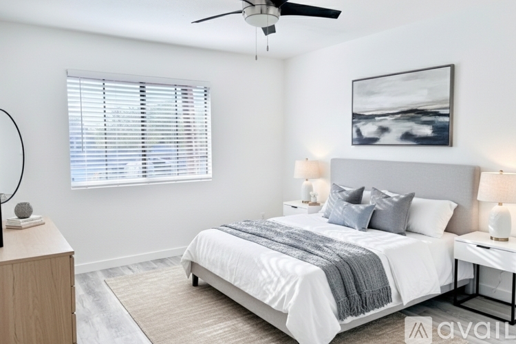 A bedroom with a bed, nightstands, and a ceiling fan.