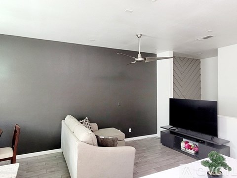 A living room with a white couch and a television.