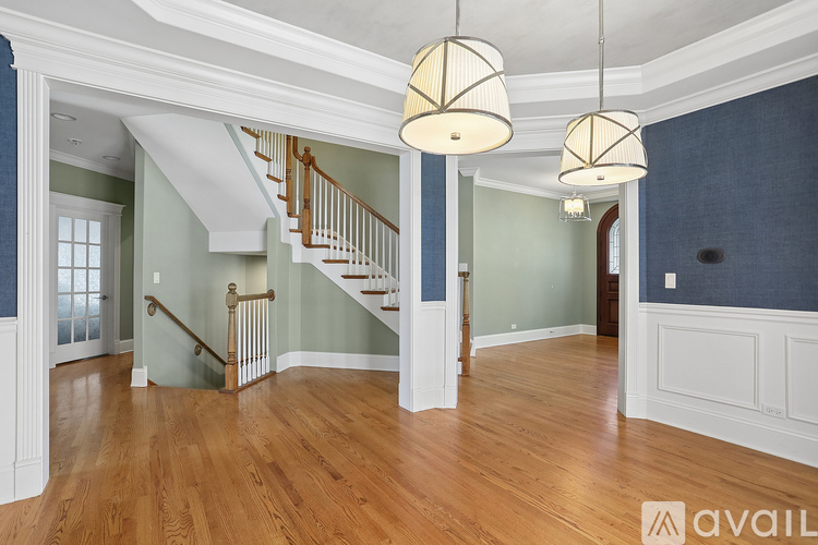 A spacious room with a staircase and two hanging lights.