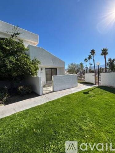 A modern house with a white exterior and a green lawn.
