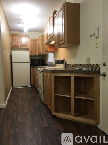 A kitchen with wooden cabinets and a white refrigerator.